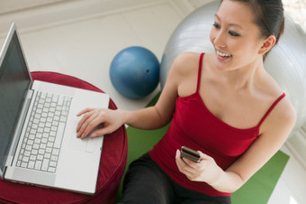Photo image of a fitness professional reading her latest edition of fitness newletter/ezine on her laptop.